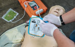 CPR Works of Charlotte Learning. Person practicing CPR on a dummy.